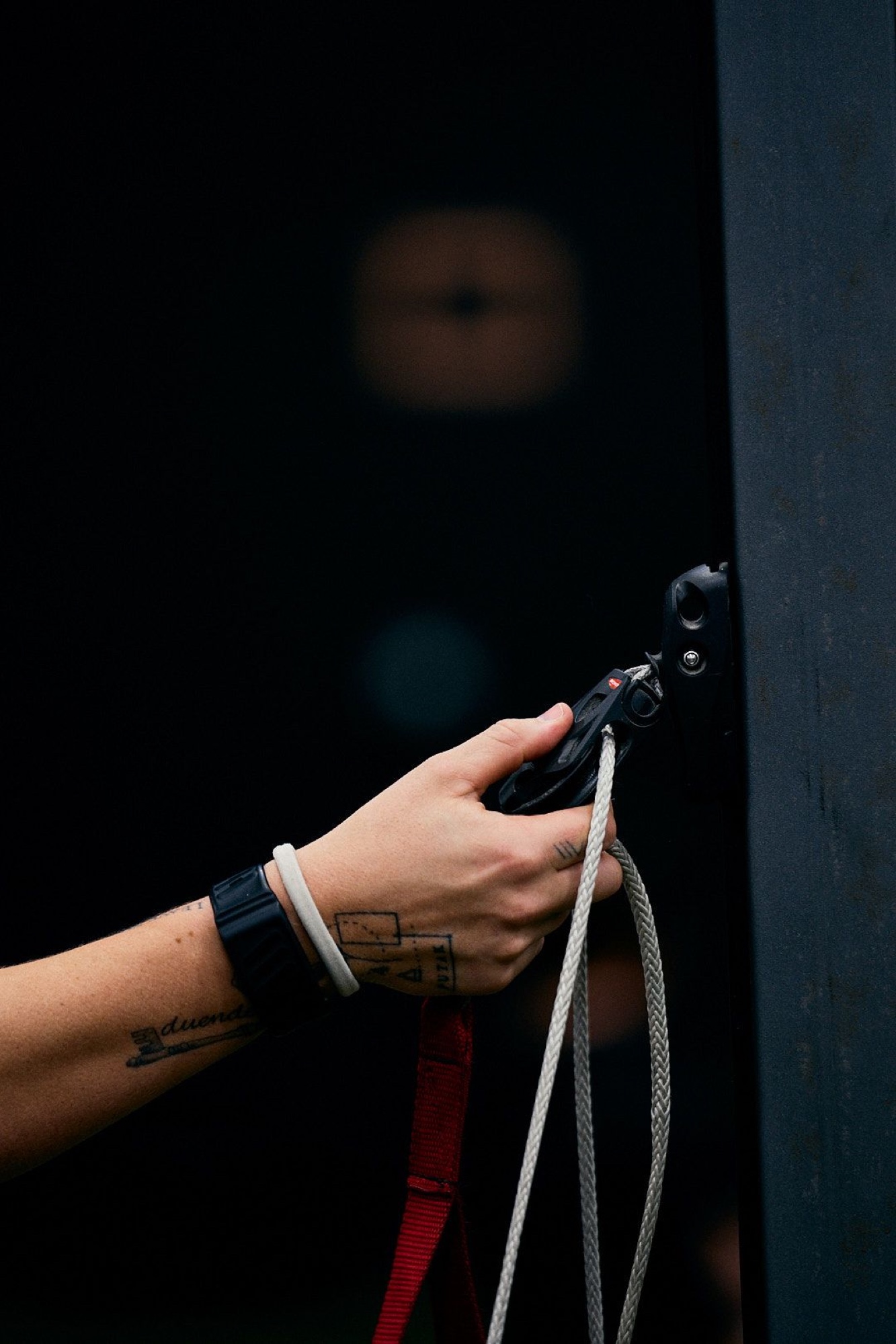 A hand clipping a carabiner to a line.