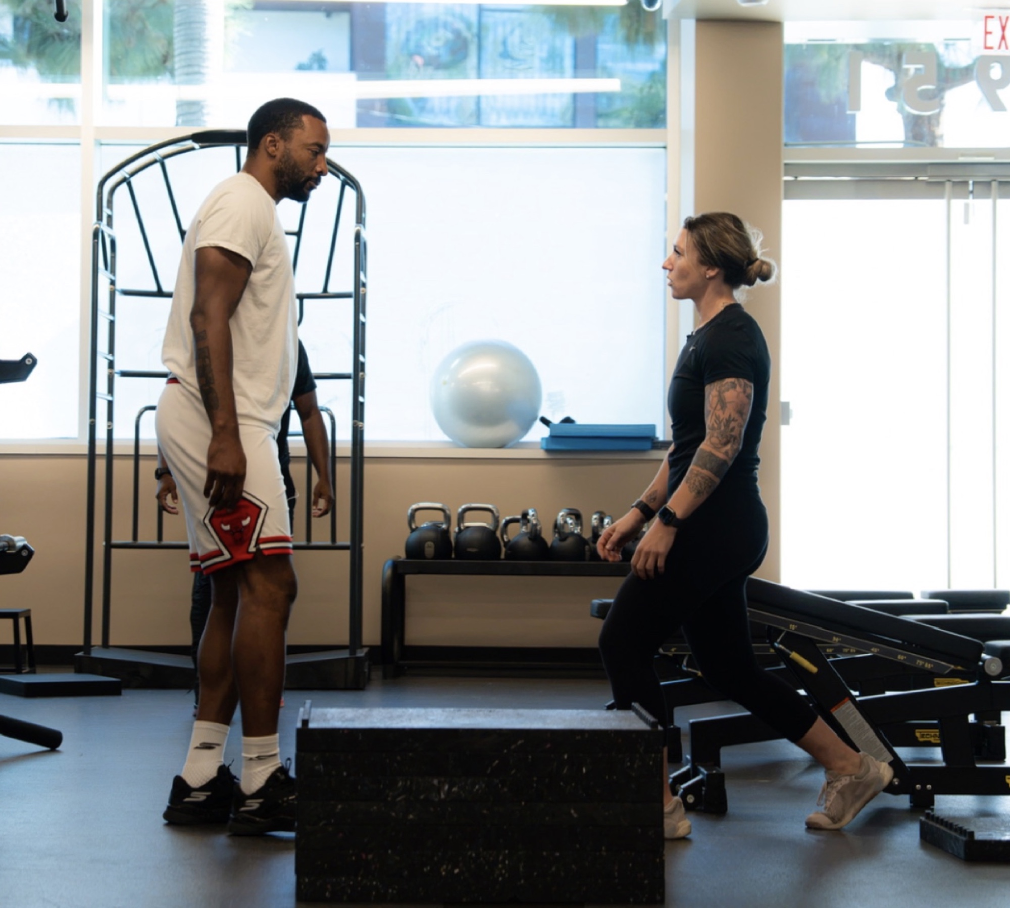 Alex Hubelbank working with a player in a gym.